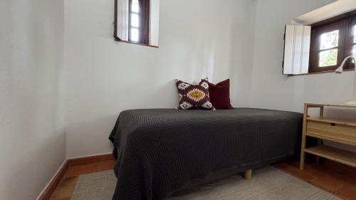 a bedroom with a bed with a black blanket at RIVERSIDE RANCH by Nature Bliss in Vila Nova de Milfontes