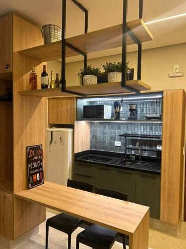 a kitchen with a wooden table and a counter with chairs at Alter Beach Flat in Alter do Chao