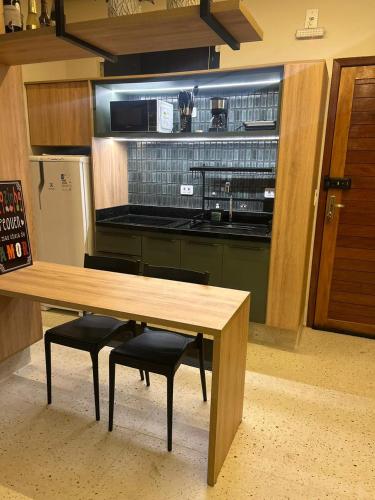 a kitchen with a wooden table and two chairs at Alter Beach Flat in Alter do Chao
