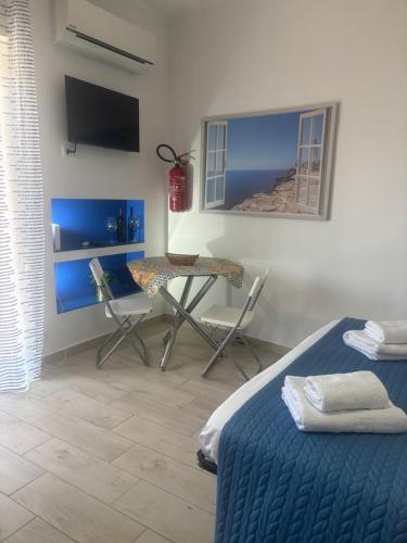 a bedroom with a table and a bed and a table and chair at c'est la vie giardini in Giardini Naxos
