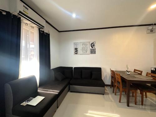 a living room with a black couch and a table at A and A Homestay Tandag City 