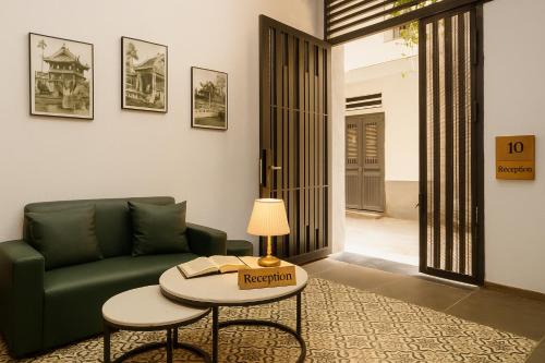 a living room with a green couch and a table at Ben's Premier Hotel & Apartment - Hanoi Center in Hanoi