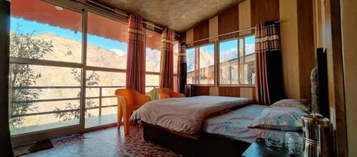 a bedroom with a bed and a large window at Kishkindha Resort in Joshīmath