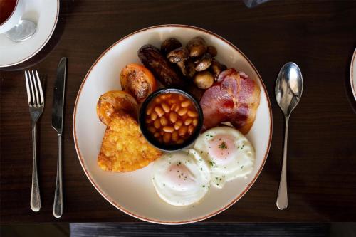 a plate of breakfast food with eggs beans and mushrooms at Radisson Blu Hotel, London Heathrow in Hillingdon