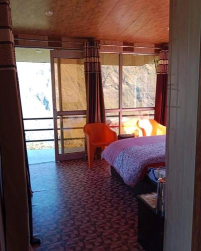 a bedroom with a bed and a large window at Kishkindha Resort in Joshīmath