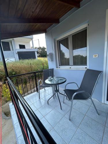 a patio with a table and chairs on a balcony at Cozy house near Preveza in Flámpoura