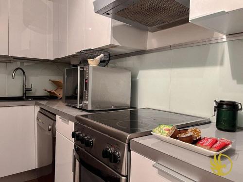 Il comprend une cuisine équipée de plaques de cuisson. dans l'établissement Confort Pro in Heart of Velizy, à Vélizy-Villacoublay