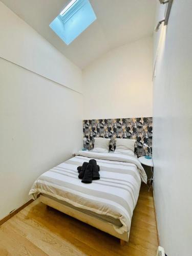 une chambre avec un lit avec des draps blancs et une fenêtre dans l'établissement Le Noeud de Bois, à Orléans