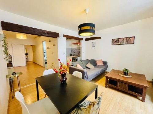 un salon avec une table et un canapé dans l'établissement Le Noeud de Bois, à Orléans