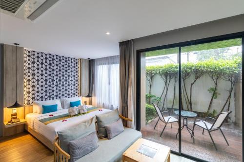 a bedroom with a bed and a large window at Antiya Hotel Phuket in Phuket Town