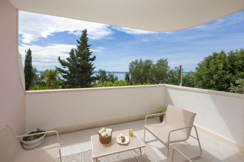 een balkon met 2 stoelen, een tafel en een raam bij Marivi - Luxury apartment above the beach Žnjan in Split