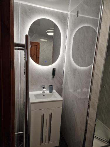 a bathroom with a sink and a mirror at Fairladies Barn Guest House in St Bees