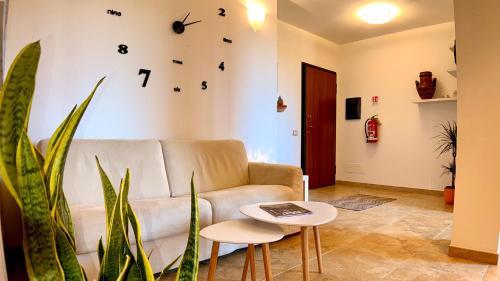 a living room with a couch and a clock on the wall at B&b Domo La Laguna in Càbras