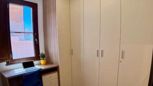 a room with a desk with a laptop and a window at B&b Domo La Laguna in Càbras