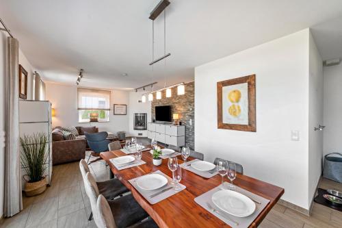 a dining room and living room with a table and chairs at Casa Fortuna in Göhren-Lebbin
