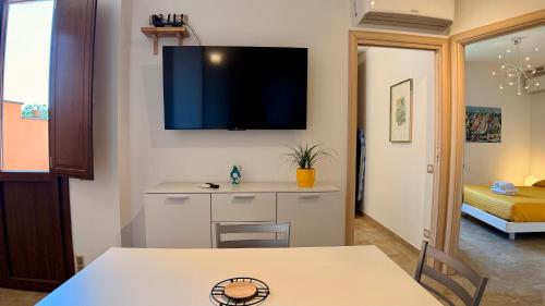 a living room with a table and a tv on the wall at B&b Domo La Laguna in Càbras