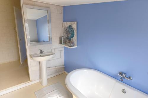 a bathroom with a tub and a sink and a toilet at Widdy's Beach Club in Umkomaas