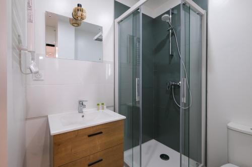 une salle de bain avec une douche en verre et un lavabo dans l'établissement Le Penhoët -Proche Gare St Nazaire, à Saint-Nazaire
