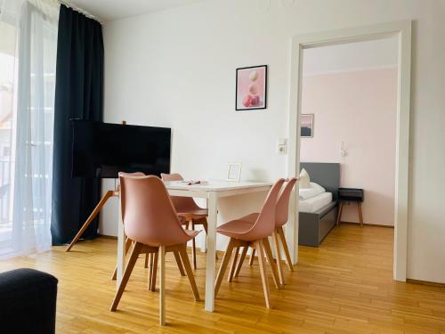 a living room with a table with chairs and a television at APSTAY City Center I FREE Parking I Self Check-in in Graz