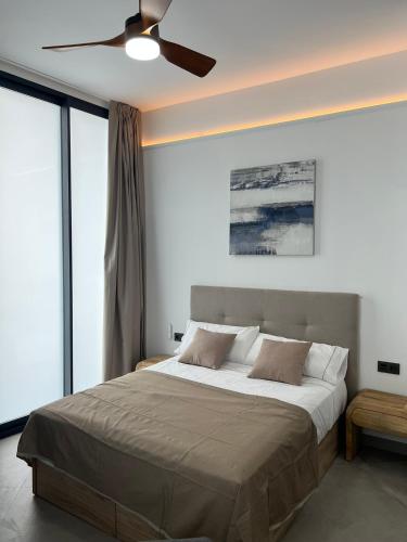 a bedroom with a large bed with a ceiling fan at Mistral Suites in Valencia