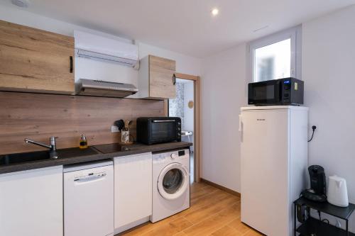 une cuisine avec un lave-linge et un micro-ondes dans l'établissement Le Penhoët -Proche Gare St Nazaire, à Saint-Nazaire