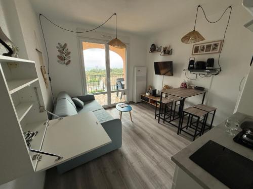 a living room with a couch and a table at Le Panorama du Tropique Saint Cyprien - Saint-Cyprien-Plage - Perpignan 66 Vue mer - Front de mer in Saint-Cyprien