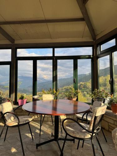 a table and chairs in a room with a view at Newly renovated 1 bedroom Flat in Tepelenë in Tepelenë