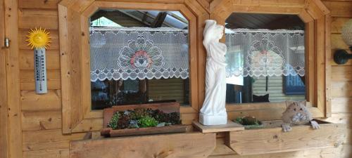 a wooden cabin with two windows and some plants at Sonnenhaus Leo Hutthurm in Hutthurm