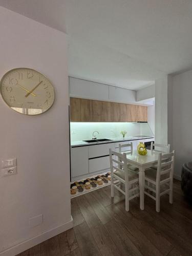 a kitchen with a table and a clock on the wall at Newly renovated 1 bedroom Flat in Tepelenë in Tepelenë