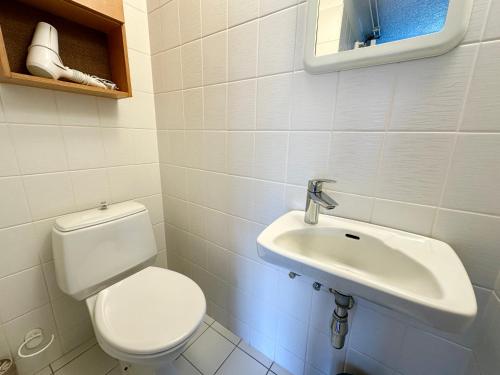 a bathroom with a toilet and a sink at Waterfront Fjord House in Litli-Árskógssandur