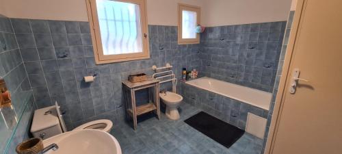 une salle de bain avec une baignoire, un lavabo et des toilettes dans l'établissement Les bichons, à Valderoure