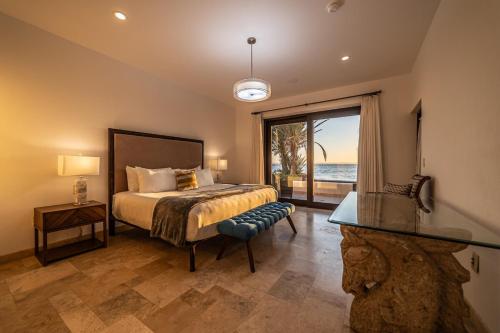 a bedroom with a bed and a view of the ocean at Luxury Oceanfront Condo at El Caimancito Beach in La Paz