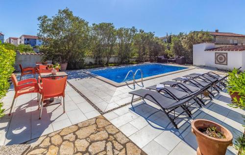 a patio with chairs and a swimming pool at Awesome Apartment In Medulin With Wifi in Medulin