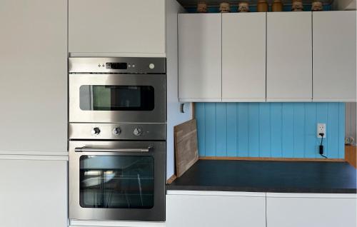 a kitchen with a stainless steel oven and white cabinets at Amazing Home In Aabenraa in Aabenraa