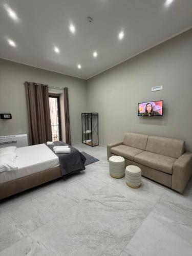 a bedroom with a bed and a couch at Palazzo Valentino in Naples