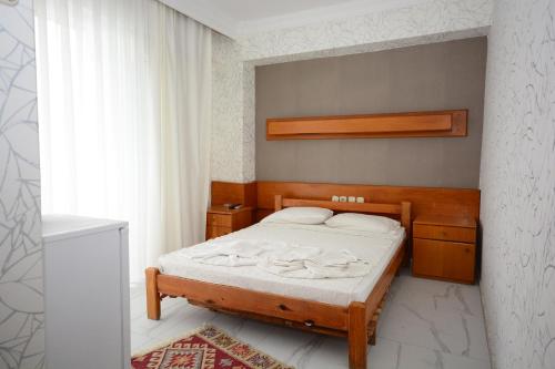 a bedroom with a bed with a wooden headboard at deniz apart hotel in Kuşadası