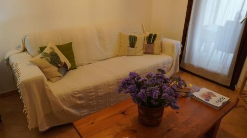 a living room with a white couch and flowers on a table at House of poppies in Brindisi