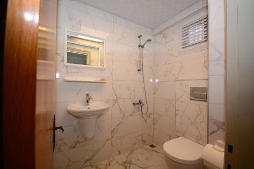 a white bathroom with a sink and a toilet at deniz apart hotel in Kuşadası