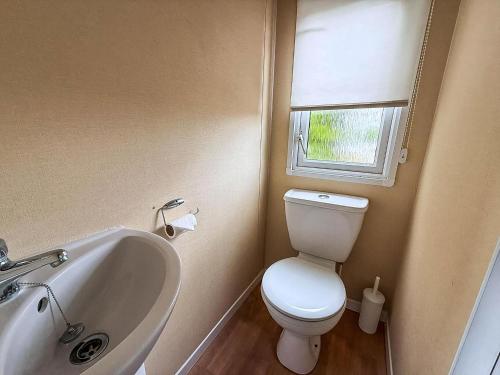 un bagno con un water, un lavandino e una finestra di Great Dog Friendly Caravan To Hire With Field Views In Norfolk Ref 10132B a Belton
