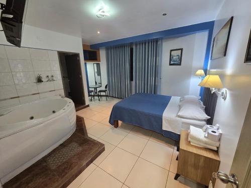 a hotel room with a bed and a bath tub at Hotel los angeles in Huaral