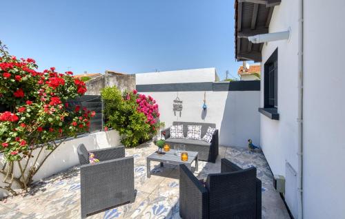 eine Terrasse mit Tisch und Stühlen und Blumen in der Unterkunft Stunning Home In Royan in Royan