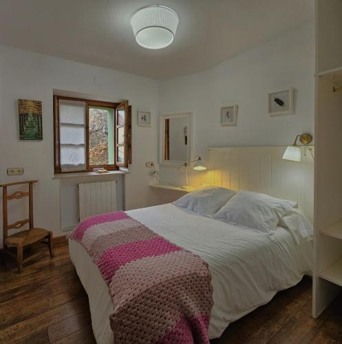 a bedroom with a large bed with a blanket on it at Casa Rural La Pumarada de Limés in Cangas del Narcea