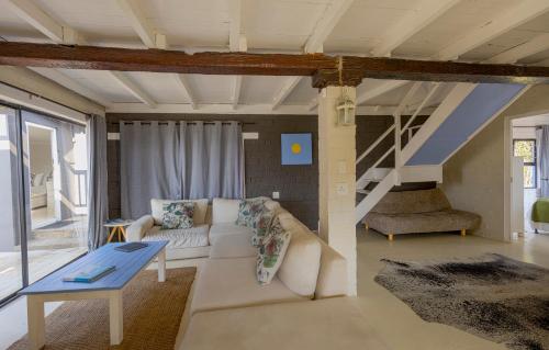 a living room with a white couch and a table at Widdy's Beach Club in Umkomaas
