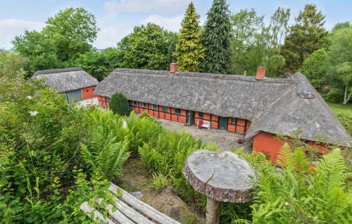 an old house with a gray roof in a garden at 5 Bedroom Cozy Home In Ørsted in Ørsted