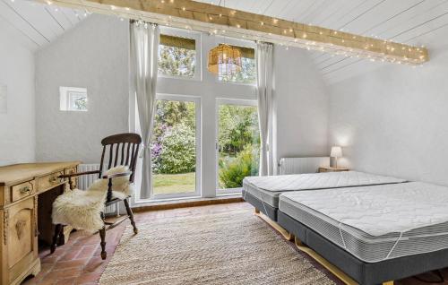 a bedroom with a bed and a desk and windows at 5 Bedroom Cozy Home In Ørsted in Ørsted