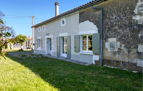 an old stone house with green windows and a yard at Holiday Home On A Vineyard in Savigné