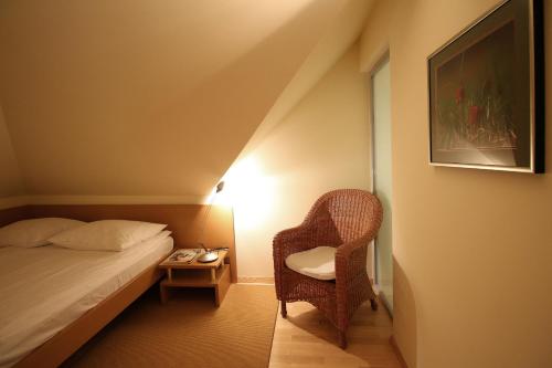 a bedroom with a bed and a chair and a table at Apartments Villa Boltez in Kranj