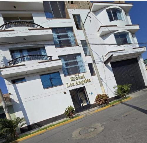 a white building with a sign on the side of it at Hotel los angeles in Huaral