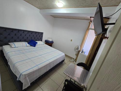a bedroom with a bed and a television in it at Hotel los angeles in Huaral