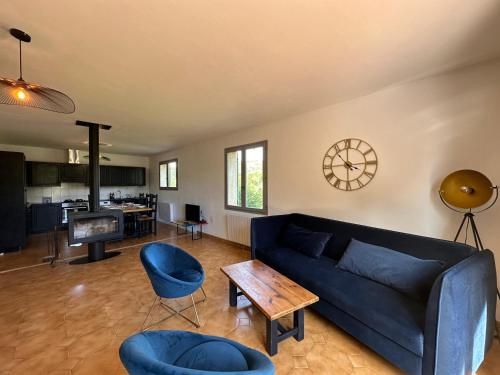 - un salon avec un canapé, des chaises et un réveil dans l'établissement La Dolce Vita Haut de villa avec jardin terrasse barbecue babyfoot parking entre Aix et Marseille, à Simiane-Collongue